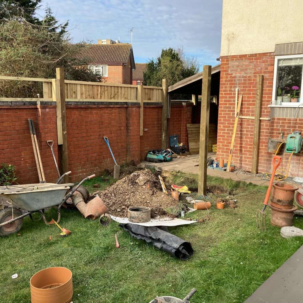 Excavation for garden drainage system installation and landscaping improvement.